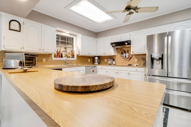 kitchen with under cabinet range hood, stainless steel appliances, a peninsula, a sink, and white cabinets