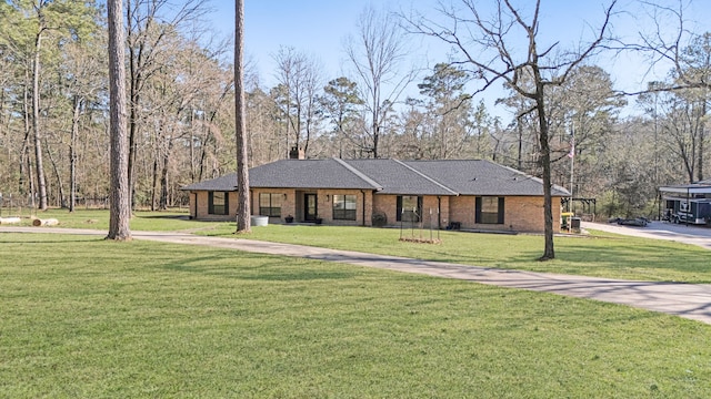 view of front of house featuring brick siding, a chimney, a front yard, and a shingled roof