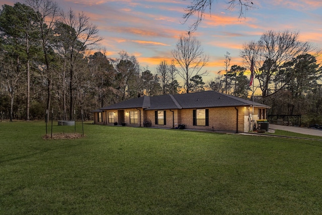 view of front of property with a front yard, brick siding, and driveway