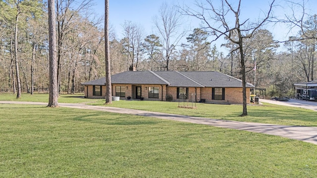 ranch-style home featuring driveway, a chimney, brick siding, and a front lawn