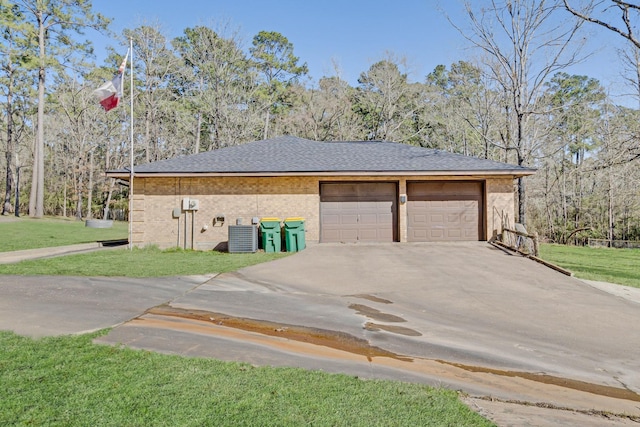view of side of property with driveway, cooling unit, an outbuilding, a lawn, and brick siding
