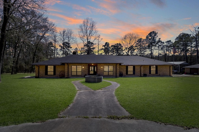 view of front of home with a chimney, brick siding, and a front lawn
