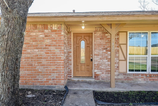 entrance to property featuring brick siding