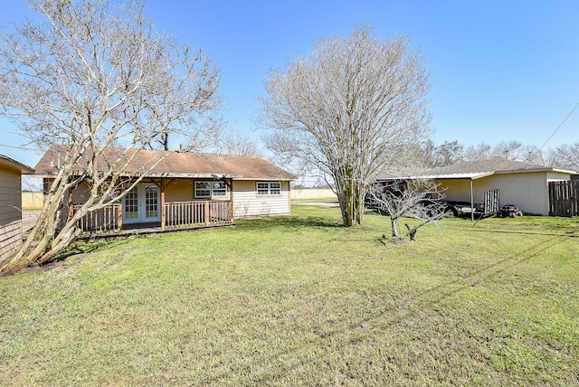 view of yard featuring french doors and fence