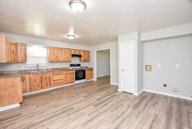 kitchen with light wood-style flooring, under cabinet range hood, baseboards, and white gas range