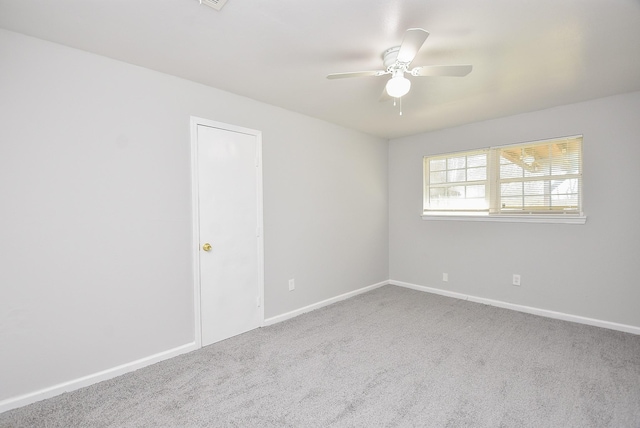 spare room with carpet, visible vents, baseboards, and a ceiling fan