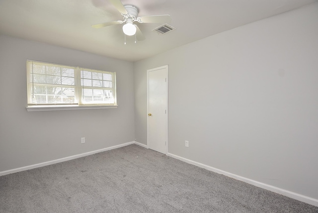 unfurnished room with carpet floors, visible vents, baseboards, and a ceiling fan