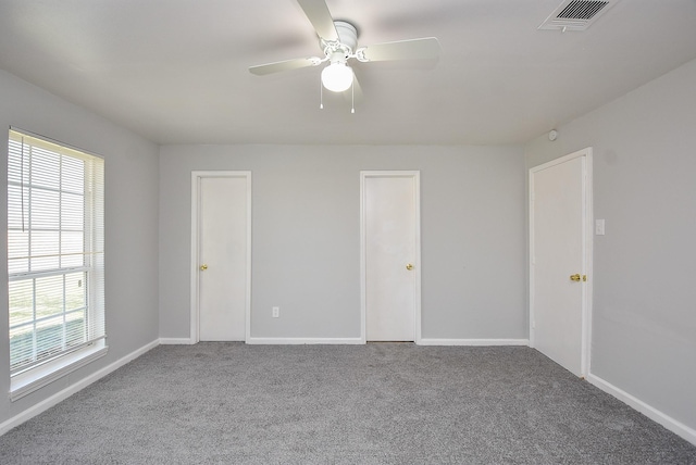 unfurnished bedroom with carpet, visible vents, and baseboards