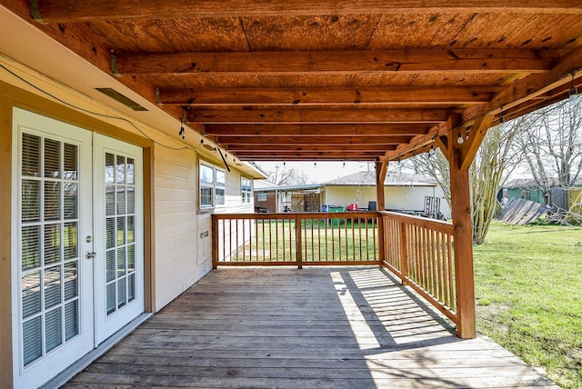 deck featuring french doors and a lawn