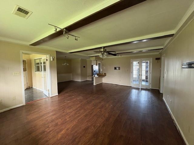 empty room featuring ceiling fan, wood finished floors, visible vents, french doors, and beam ceiling