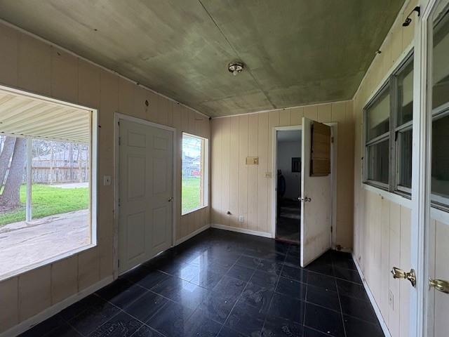 entryway with wooden walls and baseboards