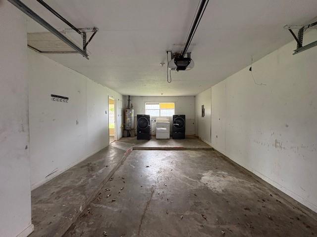 garage featuring a garage door opener, water heater, and washing machine and clothes dryer