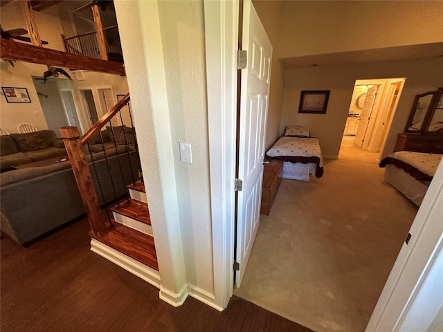 hall featuring wood finished floors, carpet flooring, and stairs
