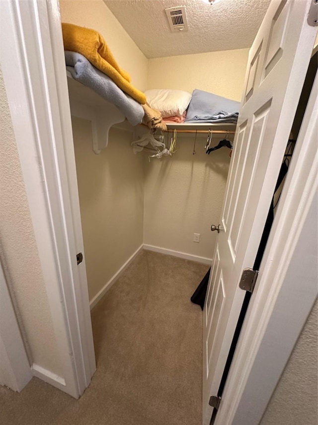 walk in closet featuring carpet flooring and visible vents