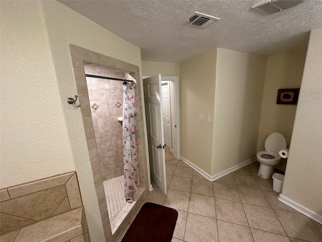 bathroom featuring toilet, a stall shower, visible vents, and tile patterned floors