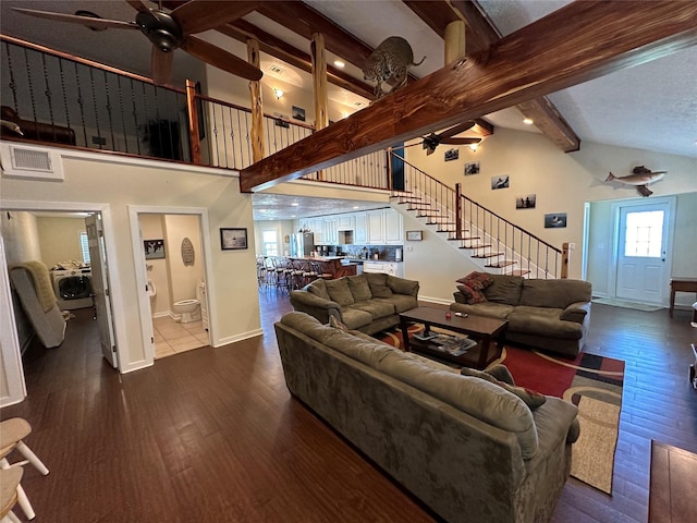living area with wood finished floors, ceiling fan, and stairs