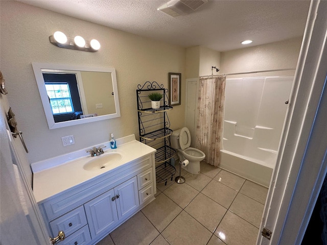 bathroom with visible vents, toilet, vanity, a textured ceiling, and tile patterned floors