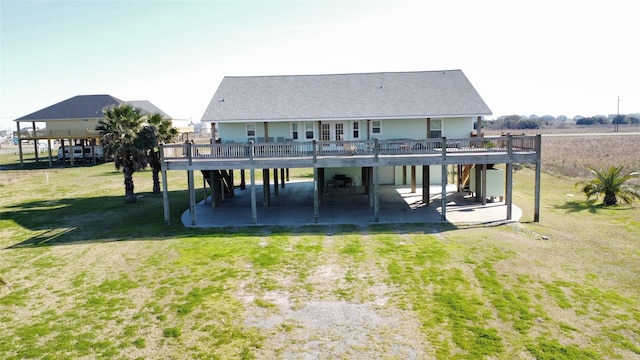 rear view of house with driveway, a patio, a deck, a yard, and a carport