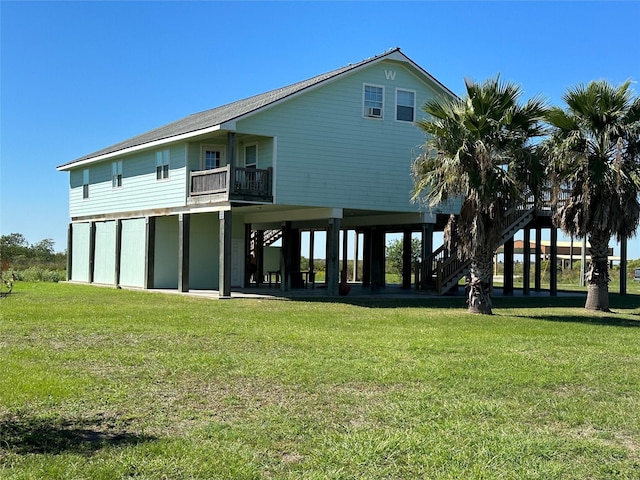 rear view of house featuring stairs, a carport, and a yard