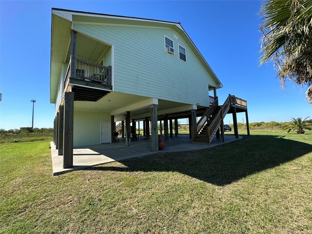 rear view of house with a patio, stairway, and a lawn