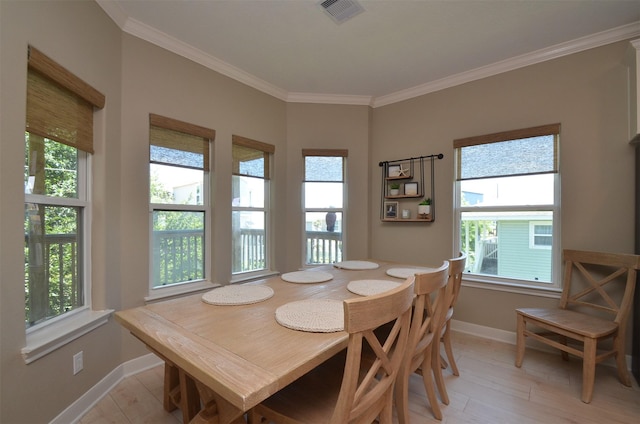 dining area featuring visible vents, crown molding, light wood finished floors, and baseboards