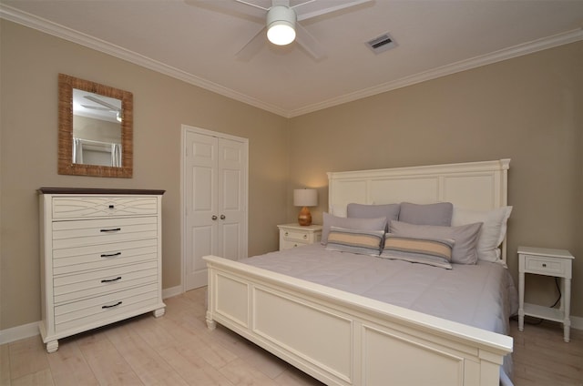 bedroom featuring light wood finished floors, a closet, visible vents, ornamental molding, and baseboards