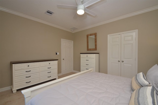 bedroom with light wood-style floors, baseboards, visible vents, and crown molding