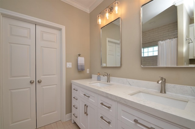 full bath featuring double vanity, ornamental molding, and a sink