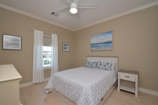 bedroom featuring ornamental molding, light wood finished floors, visible vents, and baseboards