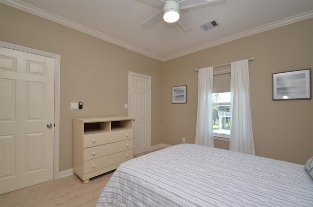 bedroom with ceiling fan, visible vents, light wood-style floors, baseboards, and crown molding