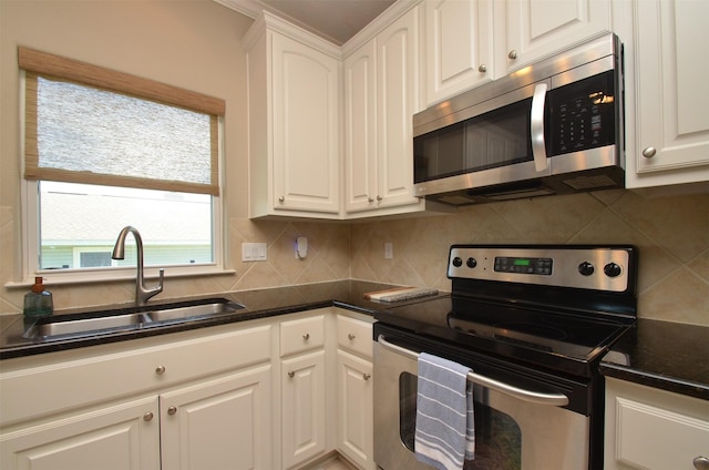 kitchen featuring stainless steel appliances, tasteful backsplash, a sink, and white cabinetry