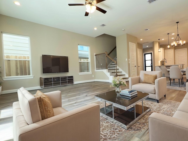 living area with visible vents, wood finished floors, recessed lighting, stairway, and baseboards