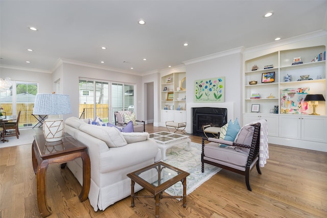 living room with ornamental molding, a fireplace with flush hearth, light wood-style flooring, and recessed lighting