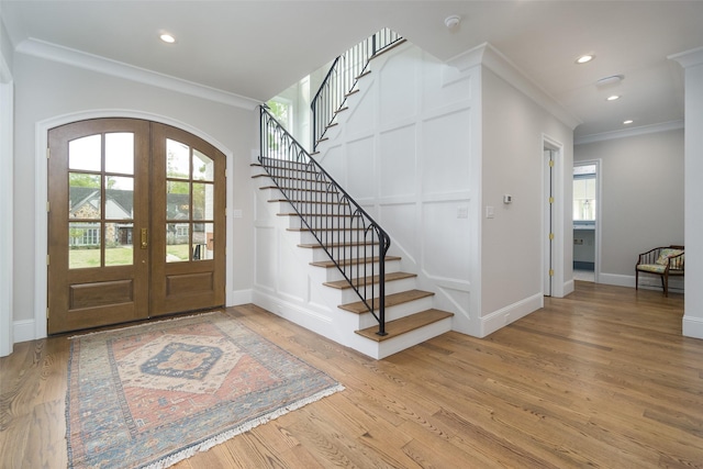 foyer entrance featuring a healthy amount of sunlight, arched walkways, a decorative wall, and french doors