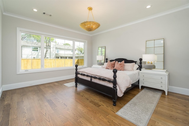 bedroom with recessed lighting, wood finished floors, visible vents, baseboards, and crown molding