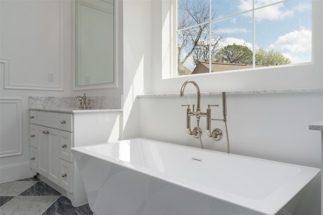 bathroom featuring a freestanding tub and vanity