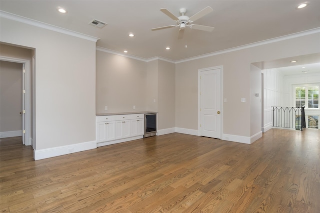 empty room with crown molding, recessed lighting, visible vents, light wood-type flooring, and baseboards