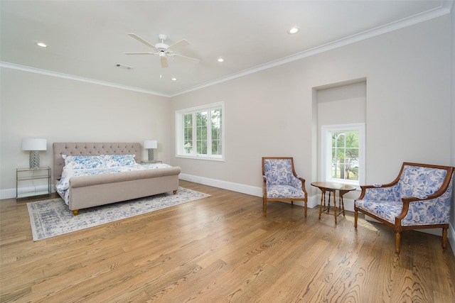 bedroom with light wood-type flooring, multiple windows, visible vents, and crown molding