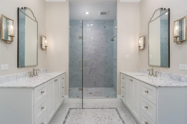 bathroom with a stall shower, two vanities, and a sink