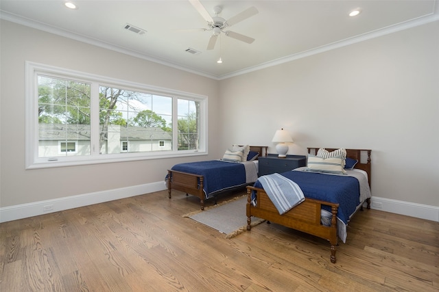 bedroom featuring light wood-style flooring, visible vents, baseboards, and ornamental molding