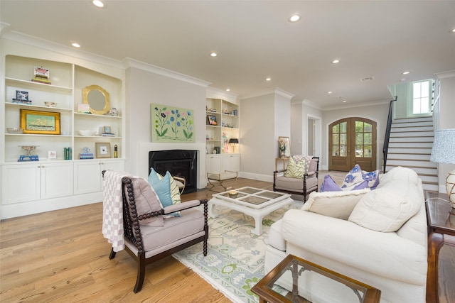 living area with light wood finished floors, stairway, french doors, a fireplace, and recessed lighting