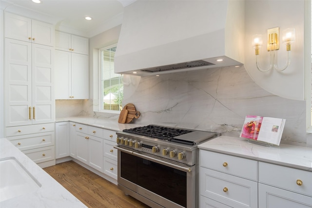 kitchen with white cabinetry, double oven range, custom exhaust hood, and light wood-style flooring