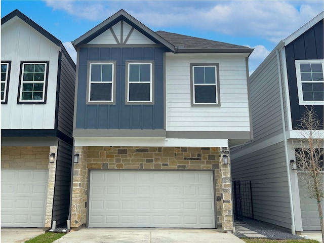 view of front facade featuring an attached garage, stone siding, and board and batten siding