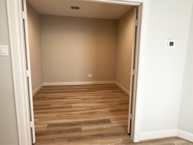 spare room with light wood-style floors, visible vents, and baseboards