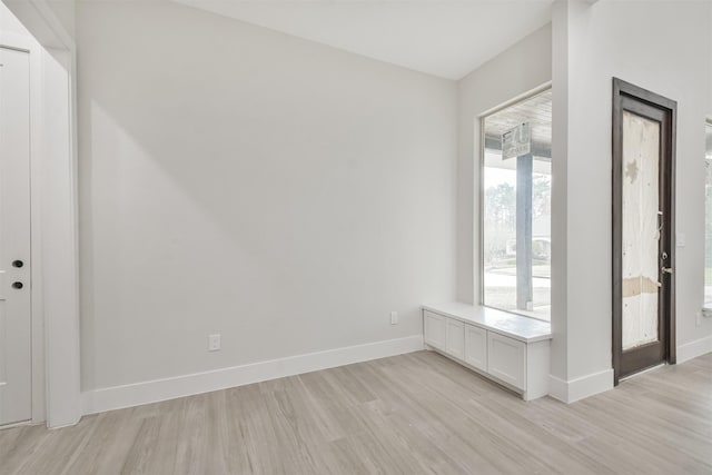 empty room featuring light wood finished floors and baseboards