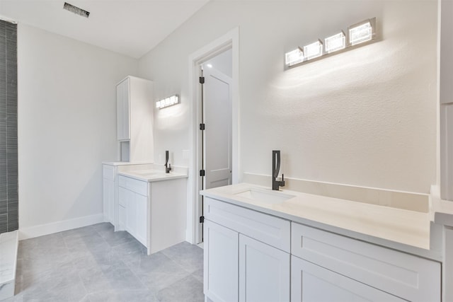 full bathroom featuring a sink, two vanities, visible vents, and baseboards