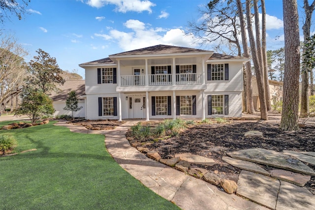 neoclassical / greek revival house with a front yard and a balcony