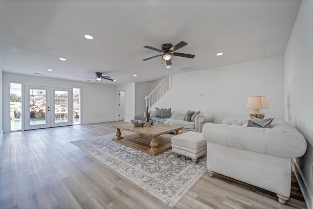 living room with light wood finished floors, visible vents, stairs, french doors, and recessed lighting