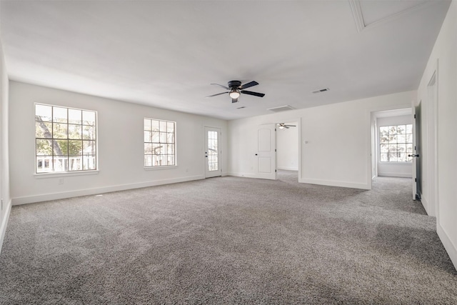 unfurnished room featuring visible vents, a ceiling fan, attic access, carpet flooring, and baseboards