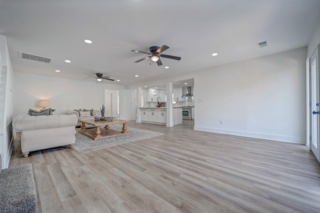 living area featuring light wood-type flooring, visible vents, and recessed lighting